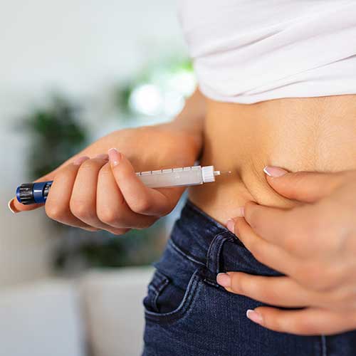 Patient administering insulin with a pen.