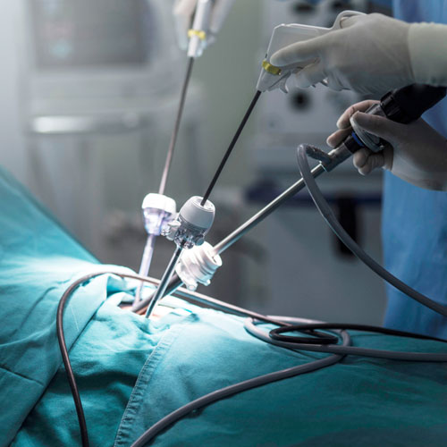 A clean, modern hospital ward featuring two beds, an operating room, and medical equipment in a well-lit environment.
