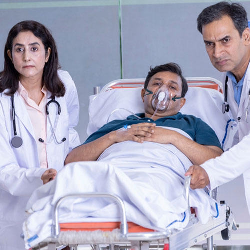 Doctors transporting a patient wearing an oxygen mask on a hospital gurney