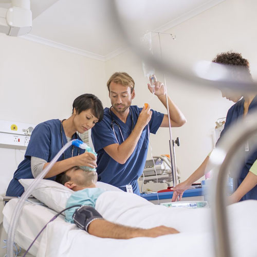 Emergency medical team providing critical care to unconscious patient in hospital – advanced life-saving treatment in progress