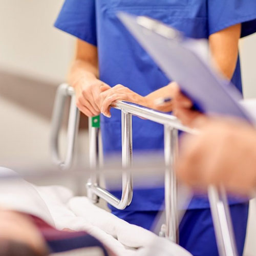 Hospital staff in blue scrubs attending to patient on stretcher – close-up of healthcare teamwork and clinical care environment